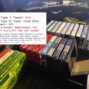May include: A collection of audio cassette tapes, some in cases, arranged in a black storage unit. The tapes are labeled with various titles and brands, including Maxell. Text on a white rectangle reads "Custom Type I Tapes: $15" and other details.
