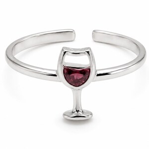 May include: A silver-toned open band ring featuring a central wine glass motif. The bowl of the wine glass is inlaid with a single, heart-shaped, deep red gemstone. The ring has a smooth, polished finish and an adjustable gap at the back.