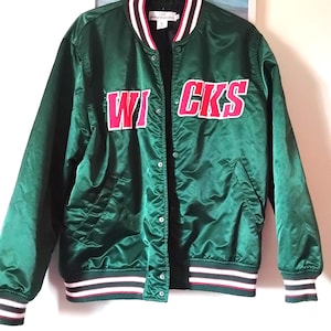 May include: A dark green satin bomber jacket with the word "WICKS" in red block letters outlined in white. The jacket has a button-up front, pockets, and striped cuffs and hem in white, red, and black.