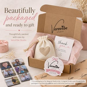 K&ouml;nnte beinhalten: Eine braune Geschenkschachtel aus Karton mit einem beigen Kordelzugbeutel mit Herzmotiv, einer Dankeskarte und einem runden Aufkleber, alles mit dem Branding von Verovibe Studio. Mehrere quadratische Fotomagnete liegen daneben auf der Fl&auml;che.