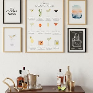 May include: A collection of framed art and barware. The art includes a cocktail menu, abstract watercolour, and a print that says "IT'S COCKTAIL -CLOCK". A bar cart displays bottles, a shaker, an ice bucket, and glasses.