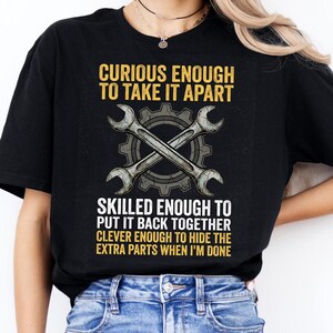 May include: Black t-shirt with the text "CURIOUS ENOUGH TO TAKE IT APART, SKILLED ENOUGH TO PUT IT BACK TOGETHER, CLEVER ENOUGH TO HIDE THE EXTRA PARTS WHEN I'M DONE." The shirt features crossed wrenches and a gear graphic.