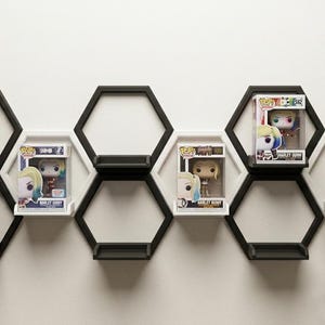 Könnte beinhalten: Eine weiße Keramiktasse mit schwarzem Henkel und dem Text "But First, Coffee" in schwarzer, fetter Schrift. Die Tasse steht auf einer Holzoberfläche. Die Tasse ist etwa 10 cm hoch.