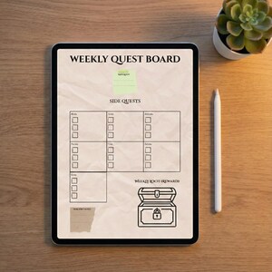May include: A digital weekly quest board displayed on a tablet. The screen features text that reads "WEEKLY QUEST BOARD" and "SIDE QUESTS". A treasure chest graphic is at the bottom. A white stylus and a small potted succulent are also visible.