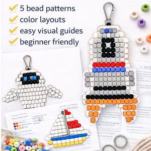 May include: A craft kit with bead patterns, color layouts, and visual guides. The image shows a variety of colorful beads, bead patterns, and a pair of pink scissors. The kit includes patterns for a robot, a sailboat, and other designs.