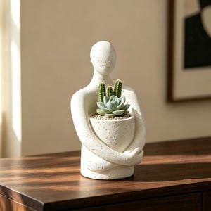 Vaso abstrato com figura humana se abraçando, ideal para suculentas. Escultura minimalista para decoração de mesa, um presente único para amantes de plantas.