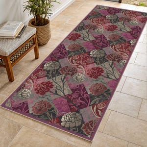 Può includere: Un tappeto runner rettangolare con un motivo floreale nei toni del bordeaux, grigio e viola. Il design presenta grandi fiori e forme geometriche. Il tappeto è posato su un pavimento piastrellato.