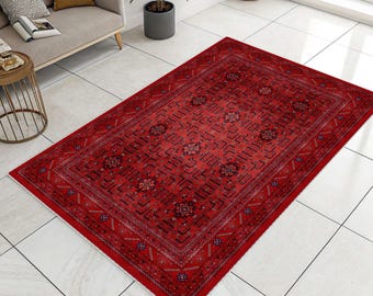 May include: A rectangular red rug with an intricate geometric pattern. The rug features a central design with repeating floral motifs and a detailed border. The color palette includes shades of red, black, and touches of cream.