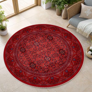 May include: A round red rug with an intricate geometric pattern. The rug features a central design with floral motifs and a border with star-like shapes. The rug is placed on a tiled floor, showcasing its vibrant color and detailed design.