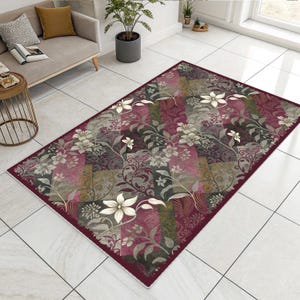 May include: Rectangular rug with a floral design in burgundy, grey, and cream. The rug has a patchwork pattern with stylised flowers and foliage. The border is a solid burgundy colour.