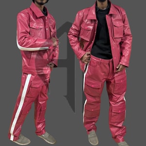 May include: A two-piece red leather outfit featuring a jacket and pants. The jacket has four pockets and a button-up front. The pants have multiple pockets and a white stripe down the side. The outfit is shown on a person.