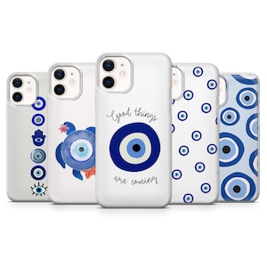 May include: A collection of white phone cases with various blue evil eye designs. One case has the text "Good things are coming". The designs include an eye, a turtle, and a hand with an eye.