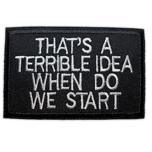 Könnte beinhalten: Schwarzer rechteckiger Aufnäher mit weiß gesticktem Text: "THAT'S A TERRIBLE IDEA WHEN DO WE START". Der Aufnäher ist zum Aufnähen oder Aufbügeln auf Kleidung oder Accessoires gedacht.