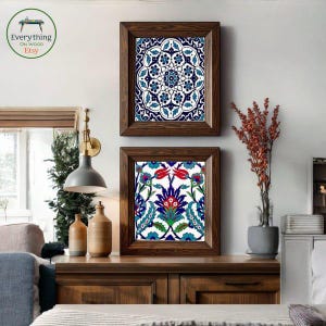 May include: Two framed art prints with intricate floral patterns in blue, white, and red hues. The frames are made of dark wood, and the prints are displayed on a wooden cabinet. The Etsy logo is visible in the top left corner.