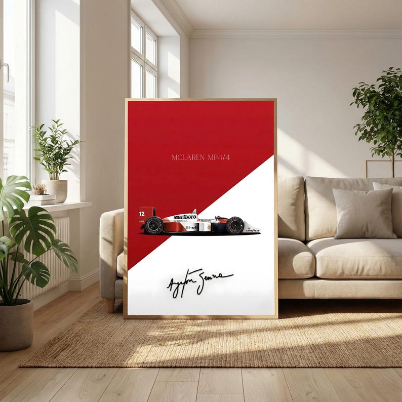 May include: Framed print featuring a McLaren MP4/4 race car in red, white, and black. The print includes the text "McLaren MP4/4" and the signature of Ayrton Senna. The artwork is displayed in a living room setting.