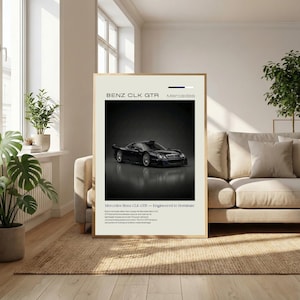 May include: A framed poster featuring a black Mercedes Benz CLK GTR race car. The poster has a cream-colored border and includes the text "BENZ CLK GTR Mercedes" at the top. The car is centered on a dark background.