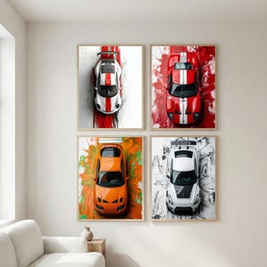 May include: Four framed wall art prints featuring overhead views of sports cars. The cars are in various colors: white with red stripes, red with white stripes, orange, and white with black accents. Each print has a unique abstract background.