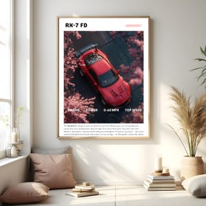 Puede incluir: Impresión enmarcada que presenta un coche deportivo Mazda RX-7 FD rojo. La imagen incluye texto en la parte superior e inferior, con detalles sobre el motor, la potencia, 0-60 mph y la velocidad máxima. El coche está sobre un fondo de flores rosas.