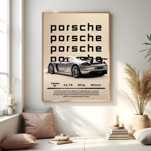 May include: A framed poster featuring a silver Porsche Carrera GT sports car. The poster includes the word "Porsche" repeated three times at the top, with technical specifications below the car, including 330 km/h.