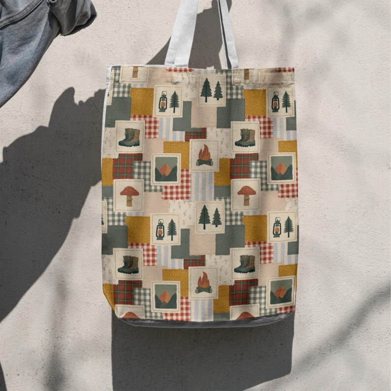 Może przedstawiać: Torba typu tote z nadrukiem w stylu patchworku, przedstawiająca powtarzające się ilustracje sosen, latarni, but&oacute;w trekkingowych, ognisk, grzyb&oacute;w i g&oacute;r, przeplatane kwadratami w czerwone, ż&oacute;łte i zielone wzory w kratę oraz paski.