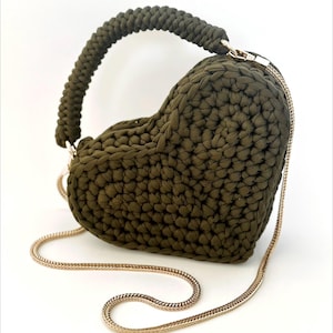 May include: Olive green heart-shaped handbag with a braided handle and a gold chain strap. The bag is made of a thick, textured material. The text "PDF Pattern" is at the top.