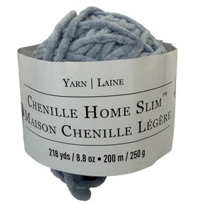 以下が含まれることがあります： 水色のシェニール糸の玉。ラベルには「YARN | LAINE」と「CHENILLE HOME SLIM」と記載されています。200mの糸が含まれています。糸は柔らかくふわふわで、編み物や編み物のプロジェクトに最適です。