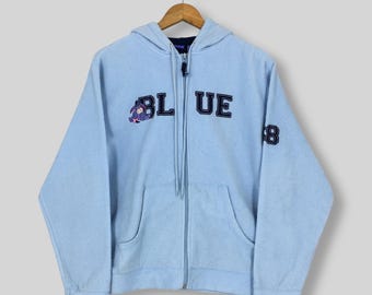 May include: Light blue zip-up hoodie with the word "BLUE" in navy blue lettering across the chest. A cartoon character is on the left side of the word "BLUE". The number "8" is on the right sleeve.
