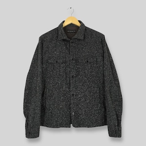 May include: A dark grey button-up shirt with a speckled pattern, two chest pockets, and a collar. The shirt is hanging on a wooden hanger. The brand name "Barneys Nicole" is visible on the collar.