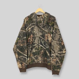 May include: A camouflage hooded sweatshirt with a brown hem and cuffs. The hoodie features a pattern of brown, green, and tan branches and leaves. The sweatshirt is suspended from a wooden hanger.