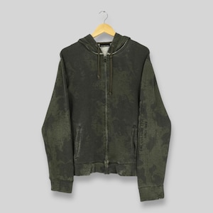 May include: A dark green zip-up hoodie with a faded, mottled pattern. The hoodie features a drawstring hood, front pockets, and a full-length zipper. The text "THE CULTURE LIVES ON SINCE 1989" is printed on the left sleeve.