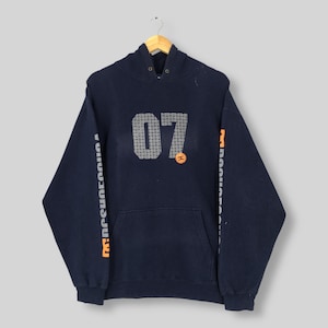 May include: Navy blue hoodie with a front pocket and a hood. The front features the number "07" in a gray, pixelated design, with a small orange logo. Orange text runs down the sleeves.