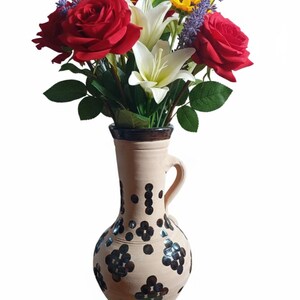 Handmade Moroccan clay water jug: traditional painted decorative pottery.