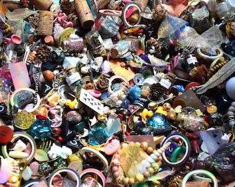 May include: A colorful assortment of small objects, including corks, beads, buttons, miniature bottles, and playing cards. The image is a close-up, showcasing a variety of textures and colors, creating a visually rich and detailed composition.