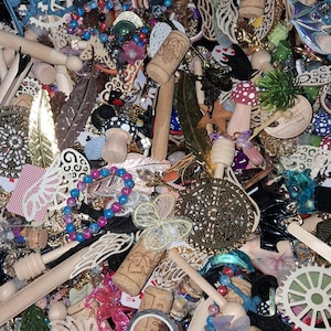 May include: A collection of various craft supplies and decorative elements. The image includes wooden dowels, corks, beads, feathers, and decorative cutouts. There are also small mushroom figurines, floral accents, and a variety of other embellishments in a mix of colors and textures.