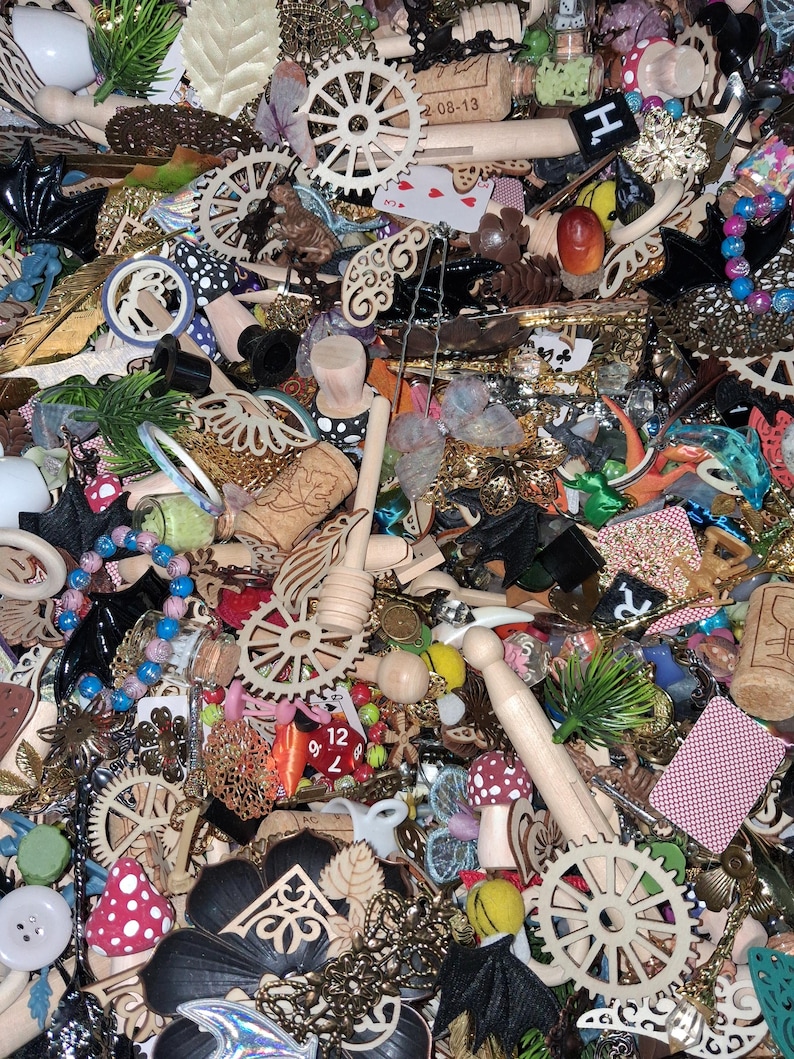May include: A collection of assorted craft supplies, including wooden gears, corks, beads, playing cards, and decorative elements. The items are in various colors and textures, creating a visually rich and diverse assortment for crafting projects.