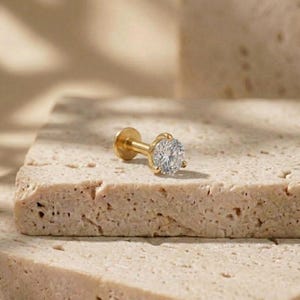 Könnte beinhalten: Ein Set aus drei Keramikbechern mit gesprenkelter, matter Oberfläche. Die Becher sind in Creme-, Hellgrau- und Dunkelgrautönen gehalten. Jede Tasse hat ein schlichtes, minimalistisches Design.