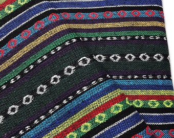May include: A close-up of a colorful woven fabric with a striped pattern. The fabric features bands of blue, red, yellow, green, and black, with white and red circular accents. The fabric is folded, revealing its texture and design.
