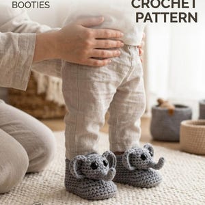 Könnte beinhalten: Graue Häkelschuhe in Elefantenform mit schwarzen Knopfaugen und Rüsseln, Teil einer VisualMints Häkelanleitung. Der Text lautet AMIGURUMI ELEPHANT BOOTIES VISUALMINTS CROCHET PATTERN und PDF Digital Download.