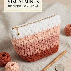 Könnte beinhalten: Gehäkelte Tasche mit Farbverlauf von Weiß über Pfirsich zu Dunkelbraun. Die Tasche hat einen goldenen Reißverschluss und einen kleinen goldenen Anhänger. Das Bild zeigt auch Wollknäuel, einen Häkelhaken und den Text "VISUALMINTS PDF PATTERN - Crochet Pouch."