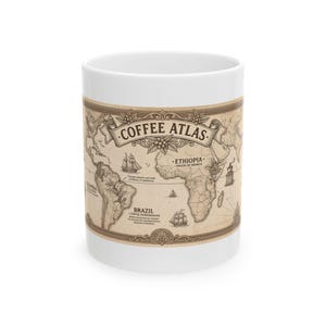 May include: A white ceramic mug featuring a vintage-style world map graphic titled COFFEE ATLAS. The design includes illustrations of sailing ships, coffee plants, and text labels for regions like Brazil, Ethiopia, and Colombia.