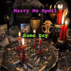 Op de afbeelding: Een altaarscène met brandende rode kaarsen, een schedel en een zilveren dienblad met kruiden. De tekst "Marry Me Spell" en "Same Day" is zichtbaar. De scène is donker en mystiek.