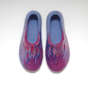 May include: A pair of blue and purple wool slippers with a red and pink design. The slippers are made of felted wool and have a soft, comfortable feel.