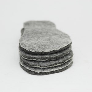 May include: A stack of five grey felt circles, each with a slightly irregular shape.