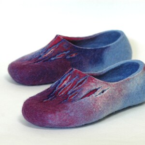 May include: A pair of blue and purple wool slippers with a unique design. The slippers have a gradient color scheme, fading from a deep purple to a light blue.