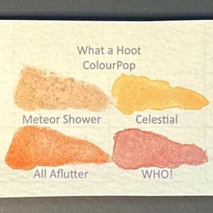 May include: A white ceramic mug with a black handle and the text "But First, Coffee" in a bold, black font. The mug is set against a blurred background, suggesting a cozy setting.