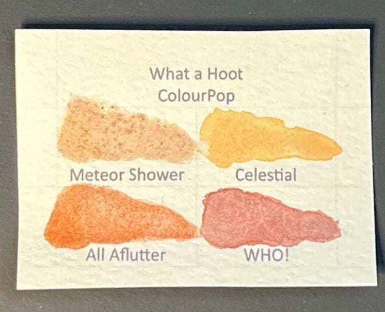 May include: A white ceramic mug with a black handle and the text "But First, Coffee" in a bold, black font. The mug is set against a blurred background, suggesting a cozy setting.