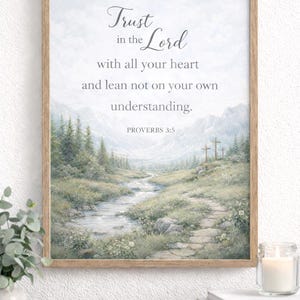 May include: A framed art print depicting a serene landscape with a river, trees, and crosses. The artwork includes the text "Trust in the Lord with all your heart and lean not on your own understanding. Proverbs 3:5" in a decorative font.