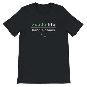 Könnte beinhalten: Schwarzes T-Shirt mit dem Text ">sudo life handle chaos" in Weiß und Grün. Das T-Shirt hat einen Rundhalsausschnitt und kurze Ärmel. Der Text ist in einer modernen, minimalistischen Schriftart.