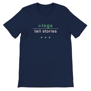 May include: Navy blue t-shirt with the text ">logs tell stories" in white and green. The shirt has a crew neck and short sleeves. Three green dots are below the text.