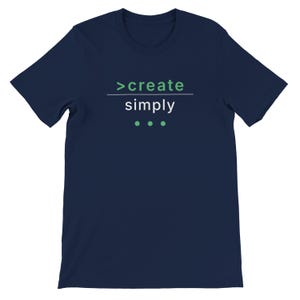 Könnte beinhalten: Marineblaues T-Shirt mit dem Text "create simply" in Weiß und Grün. Das Design beinhaltet ein grünes Größer-als-Symbol und drei grüne Punkte unter dem Wort "simply". Ein minimalistisches Design.